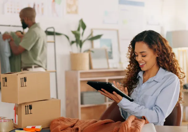 femme qui regarde sa tablette et qui prépare ses commandes ship from store depuis son magasin