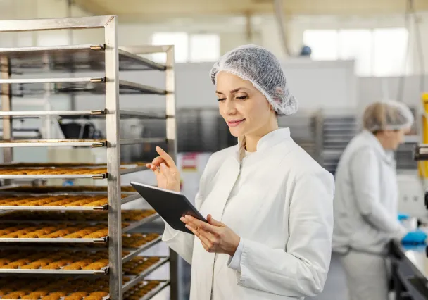 Kwaliteitsverantwoordelijke controleert een productiekar op tablet in een voedingsatelier