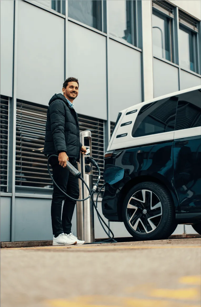 Een koerier laadt zijn elektrische bestelwagen op aan een laadpaal