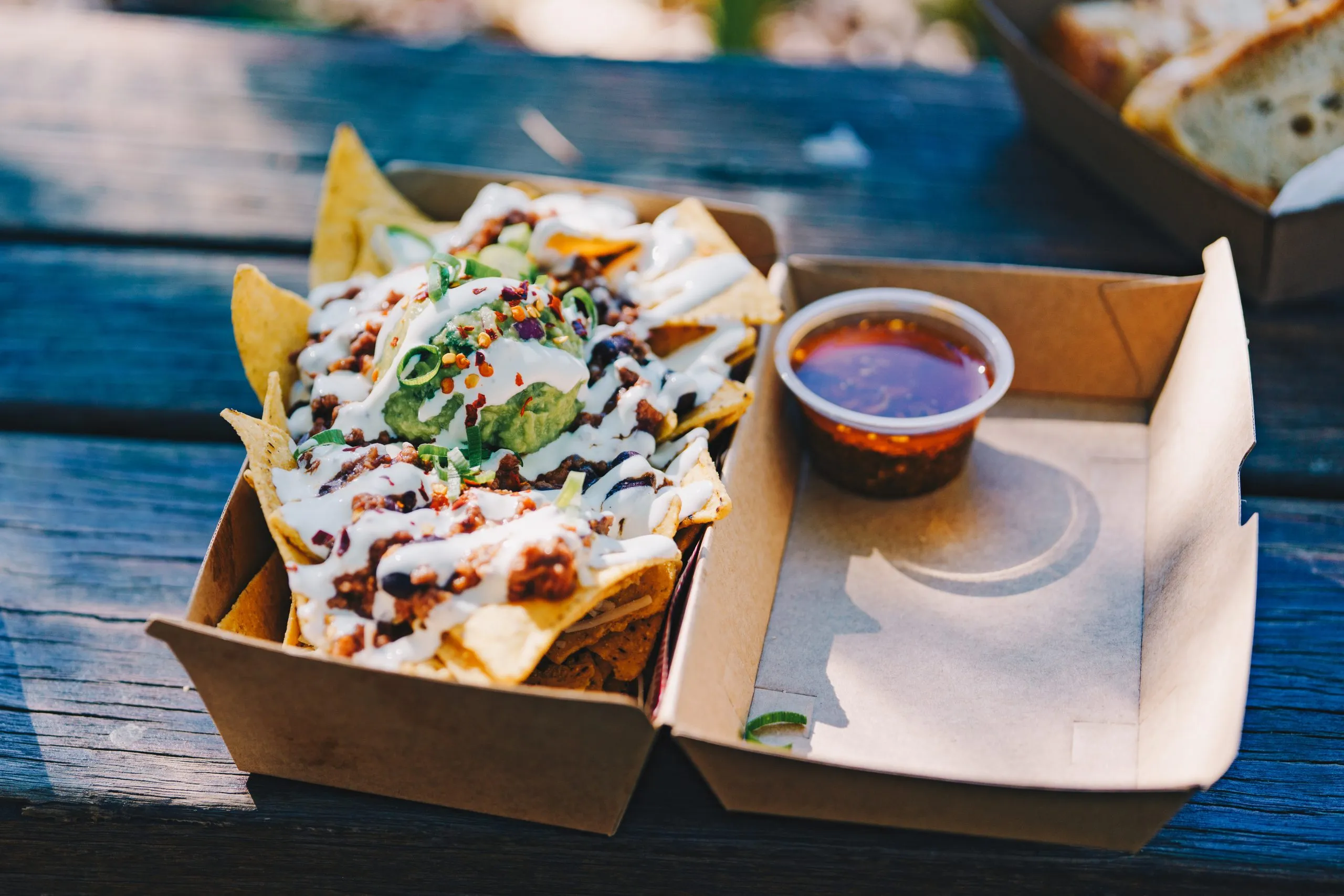 kartonnen Mexicaanse bezorgdoos gevuld met nacho’s en een saus