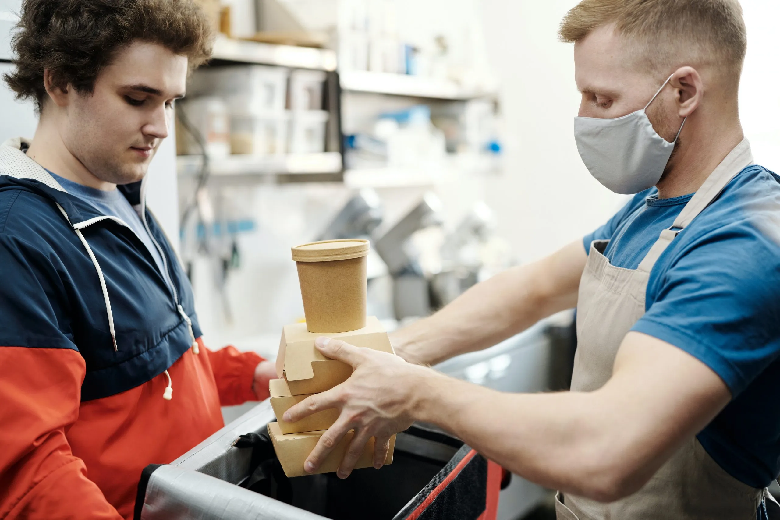 cuisinier qui met des boxes de nourriture dans un sac frigorifique