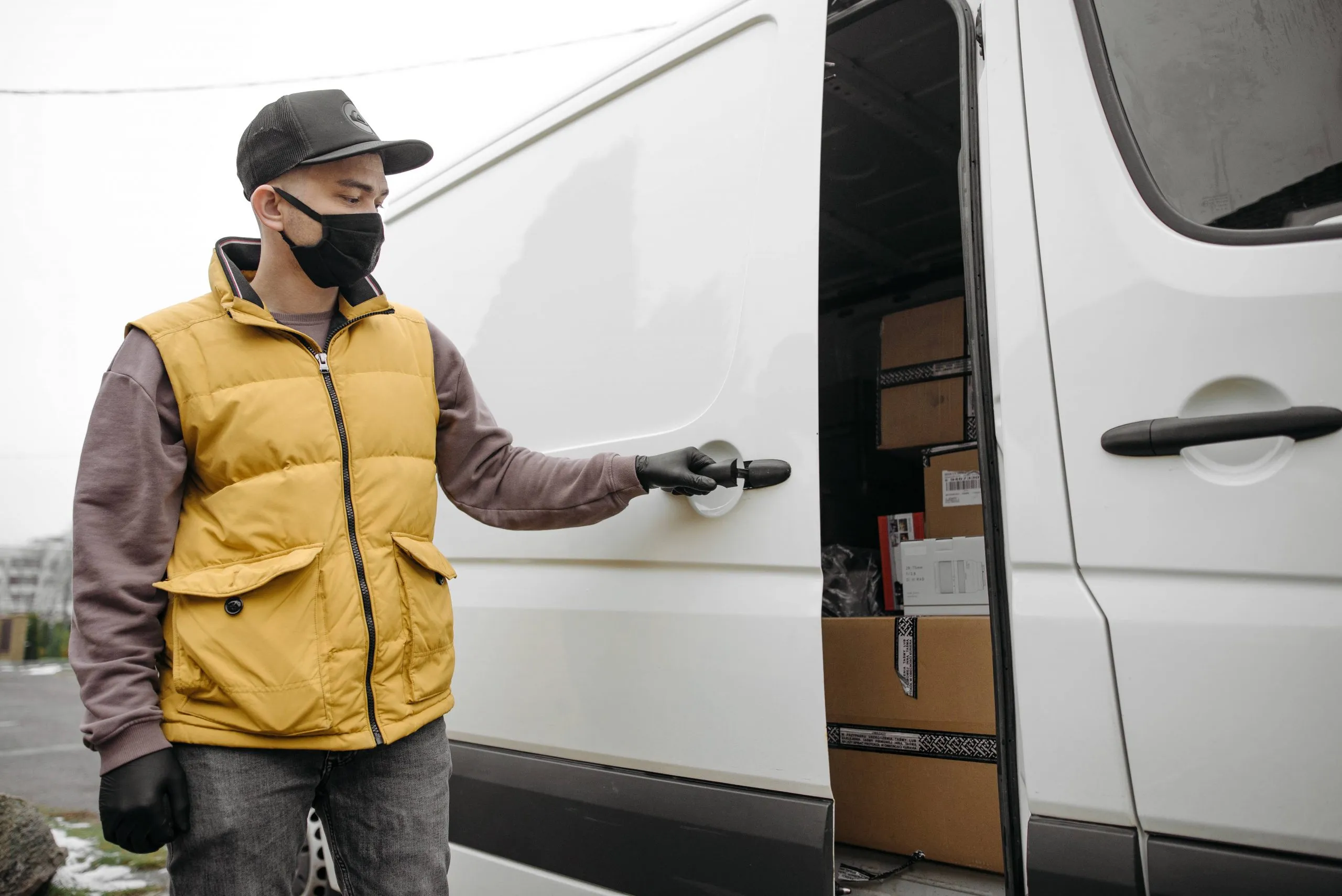 livreur fermant la porte de sa camionnette de livraison