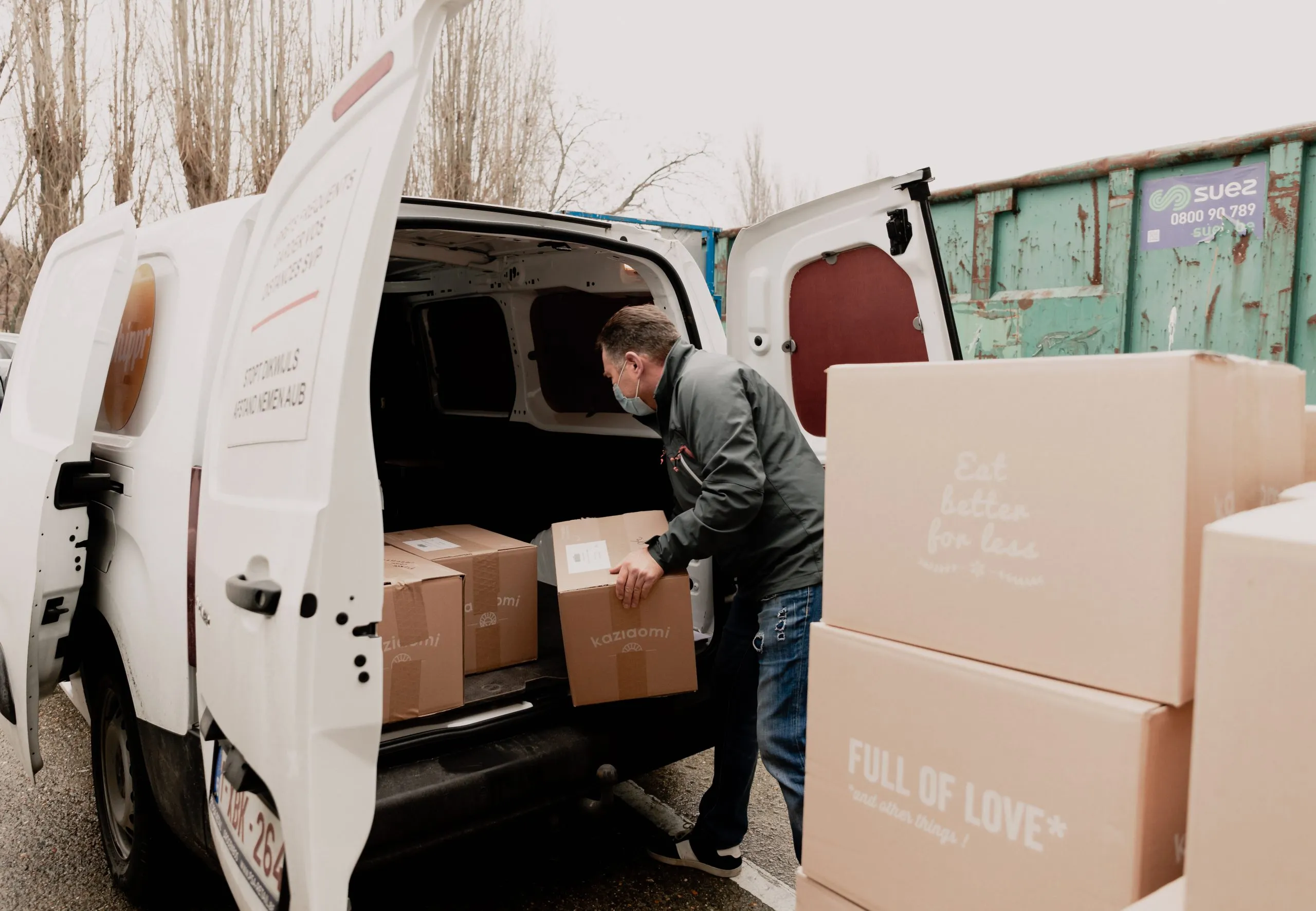Livreur qui place des caisses en carton dans une camionnette Shippr