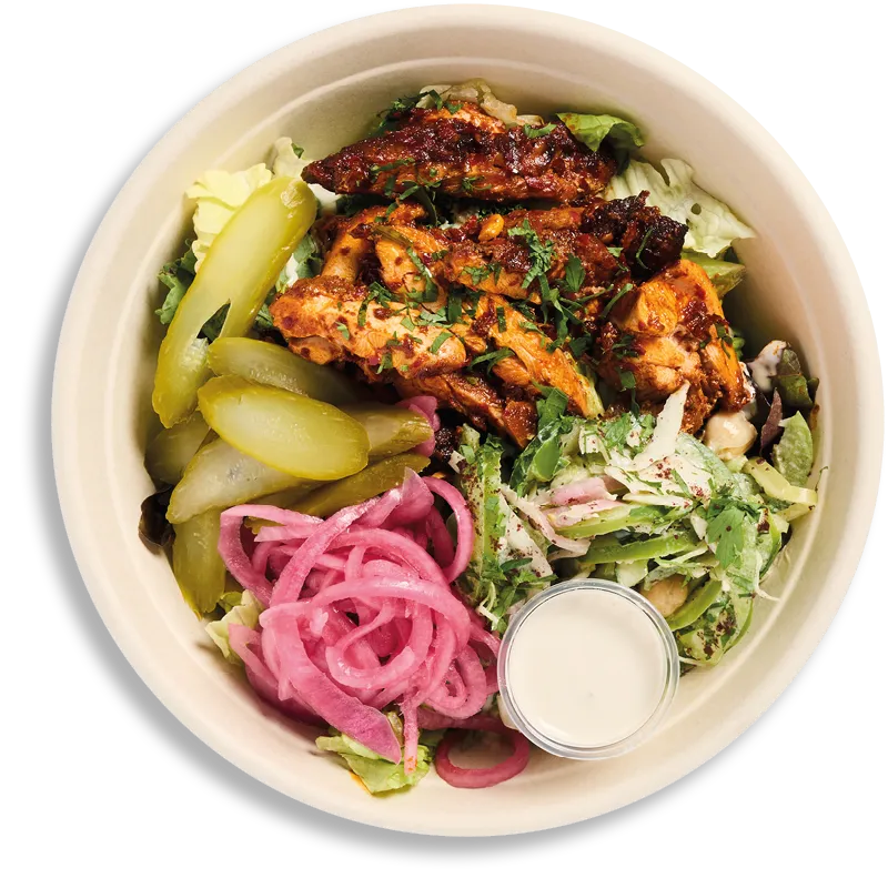Een bowl van Farmer J van bovenaf: gegrilde kip, augurken, gemarineerde rode ui, salade en een potje saus