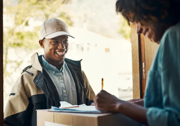 Un livreur Shippr remet un colis à une cliente sur le pas de la porte
